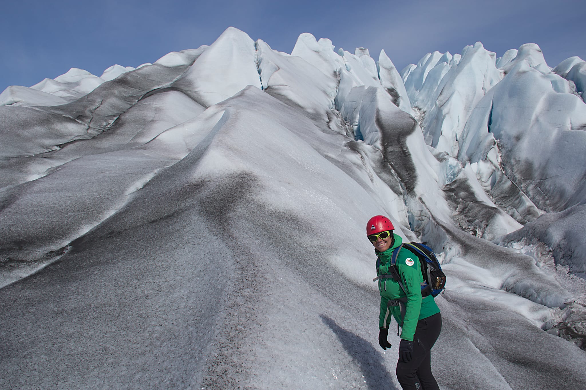 Descripción de la foto de portada: La foto está tomada en Groenlandia. Abajo a la derecha se ve a Susana de cintura para arriba en una ladera nevada en primer plano y con un paisaje de montañas de hielo y nieve al fondo.