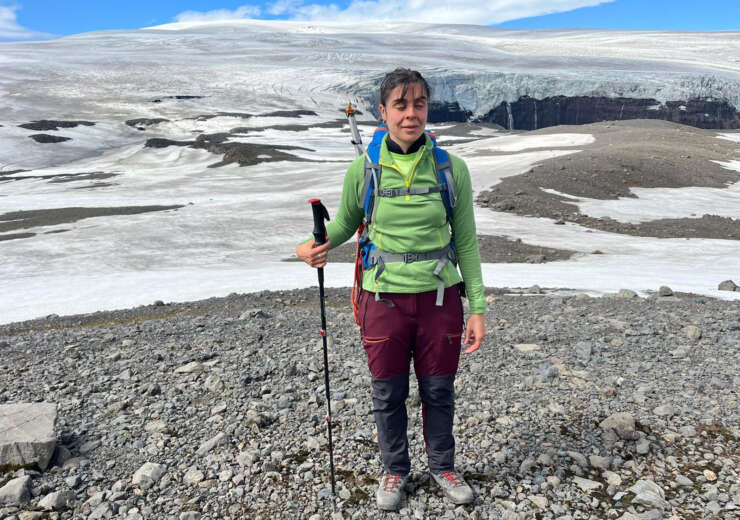 Descripción de la foto de portada: La foto está tomada en la cumbre del pico Sker, en tierras altas de Islandia. Erika está de pie y porta un bastón y su mochila. Tras ella, una espectacular vista del glaciar.