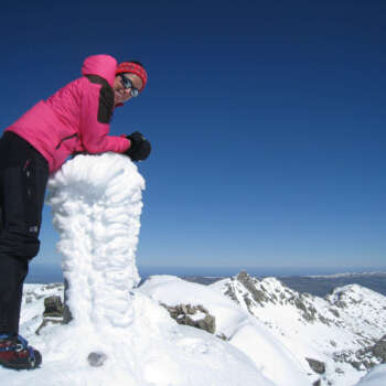 Descripción de la foto de portada: Foto invernal en la cumbre del pico Almanzor en la Sierra de Gredos. Lara aparece a la izquierda, muy sonriente apoyada en la cumbre nevada. Viste indumentaria de invierno incluidos guantes y crampones. Al fondo otras cumbres nevadas.