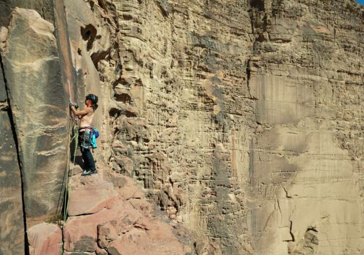 Mujer escalando en una gran pared de roca