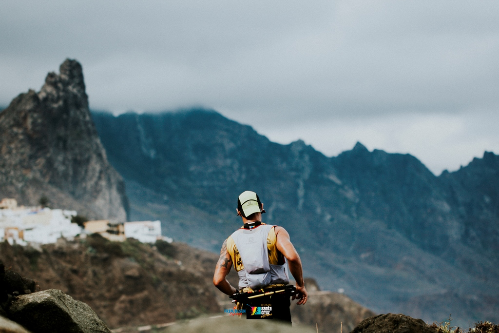 Corredor por montaña, de espalda, con un paisaje de fondo de la zona por donde discurre la carrera en la Isla de Tenerife.