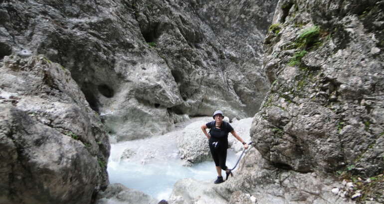 Magdalena Humbert Pons se encuentra en la Val Òten, cerca de Cortina d´Ampezzo, al norte de Italia. Es un cerrado barranco con escarpadas laderas de piedra y un río de aguas bravas al fondo. Ella aparece de pie muy cerca de agua, con ropa oscura y sombrero, agarrada a una especie de cable.